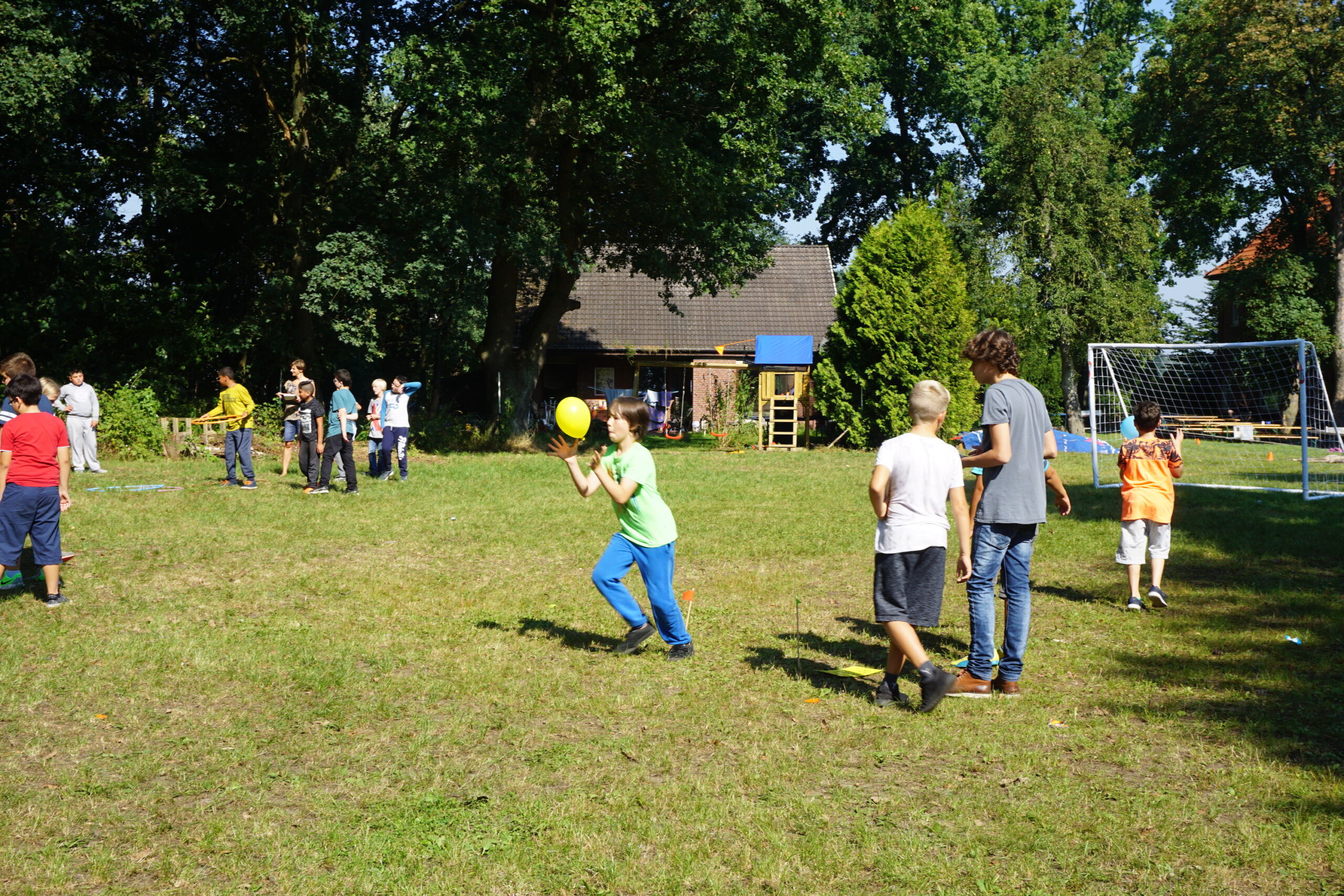 Spielende Kinder auf der großen Wiese vor dem Schullandheim Ristedt.