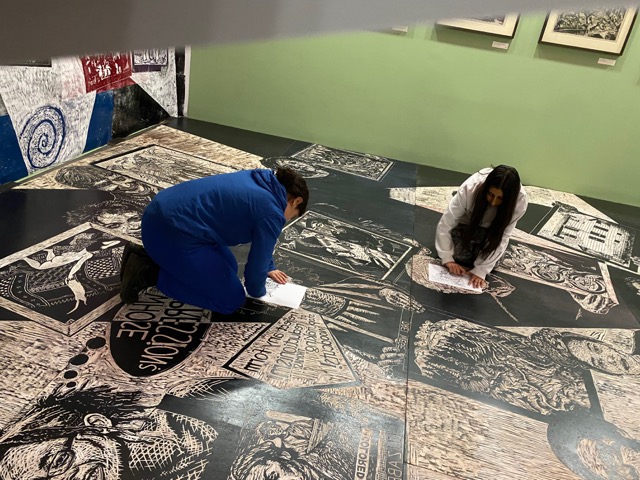 Eine Schülerin und ein Schüler sitzen auf dem Boden in einem Ausstellungsraum der Bremer Kunsthalle und zeichnen.