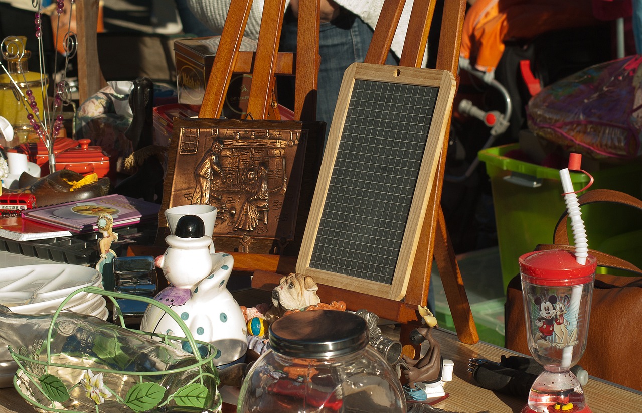 Eine Sammlung von Artikeln auf einem Flohmarktstand, einschließlich Trinkflasche und Kreidetafel.