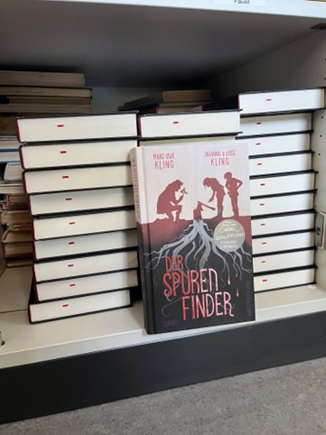 Ein Regal mit Büchern mit dem Titel "Der Spurenfinder".