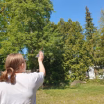 Ein Schülerin misst mit einem Förster Dreieck die Höhe eines Baums.