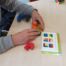 Ein Schüler baut nach Anleitung einen Würfel aus verschiedenen bunten Teilen zusammen.