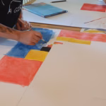Ein Kind erstellt ein Kunstwerb, angelehnt an das Bild „Äquivalenz an den Horizontalen“ von Camille Graeser.