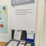 Station 2: Die Weltreise von Jeans und T-Shirt. An der Station liegt ein Taschenrechner und drei Infokarten. Zudem ein Zettel mit Aufgaben.