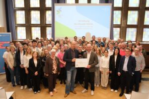 Eine Gruppe Menschen vor einer Leinwand auf der Verleihung Berufswahl-Siegel steht.