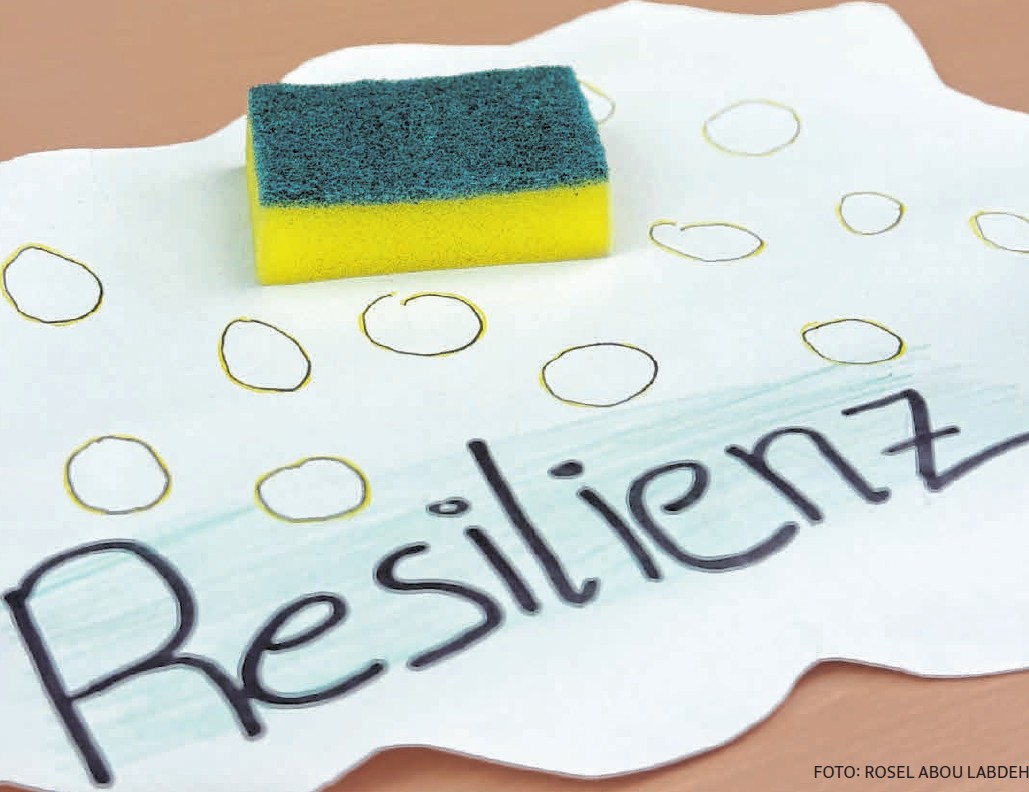 Ein Schwamm liegt auf einem Blatt Papier auf dem das Wort Resilienz steht.
